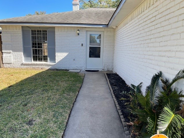 6823 Zapata Drive Houston, TX 77083 - Photo 2 of 21 Charming single-story home with a white brick exterior and a welcoming path leading to the front door. Features a well-maintained lawn and a small garden area with plants, perfect for a cozy entryway.