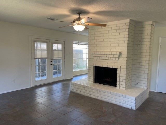 6823 Zapata Drive Houston, TX 77083 - Photo 3 of 21 This inviting living area boasts a striking white brick fireplace, tiled floors, and neutral walls. French doors open to the outdoors, enhancing the space with abundant natural light. A ceiling fan adds extra comfort.
