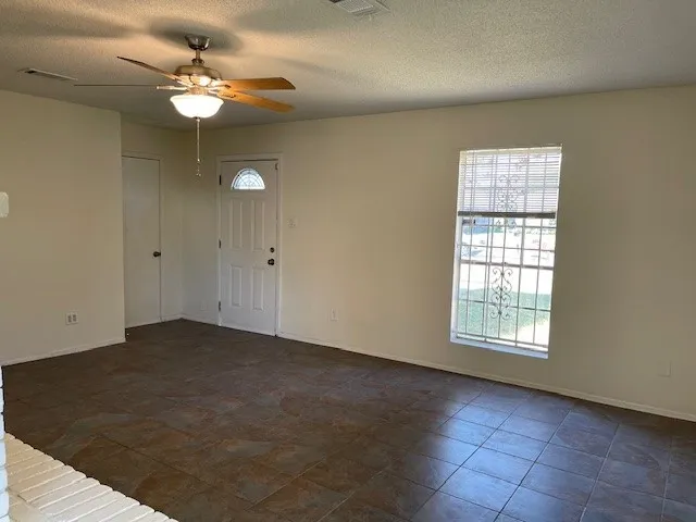 an empty room with chandelier fan