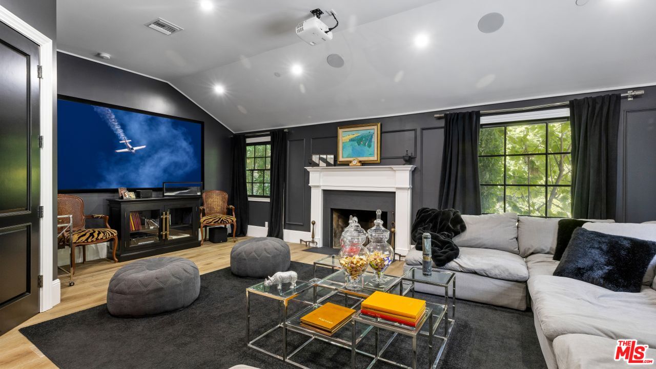 2231 Benedict Canyon Drive Beverly Hills, CA 90210 - Photo 24 of 50 a living room with furniture a fireplace and a flat screen tv