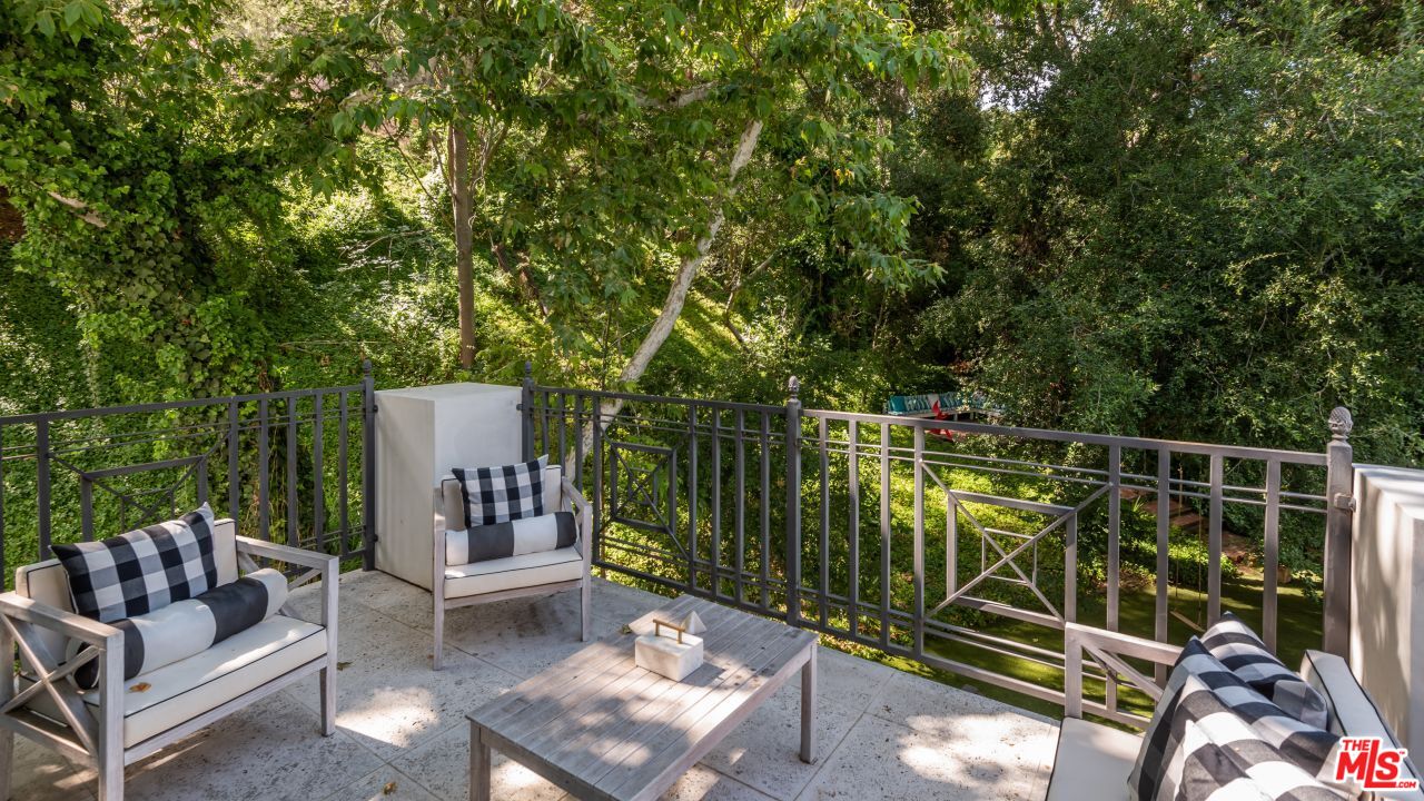 2231 Benedict Canyon Drive Beverly Hills, CA 90210 - Photo 27 of 50 a view of a chair and tables in the back yard of the house