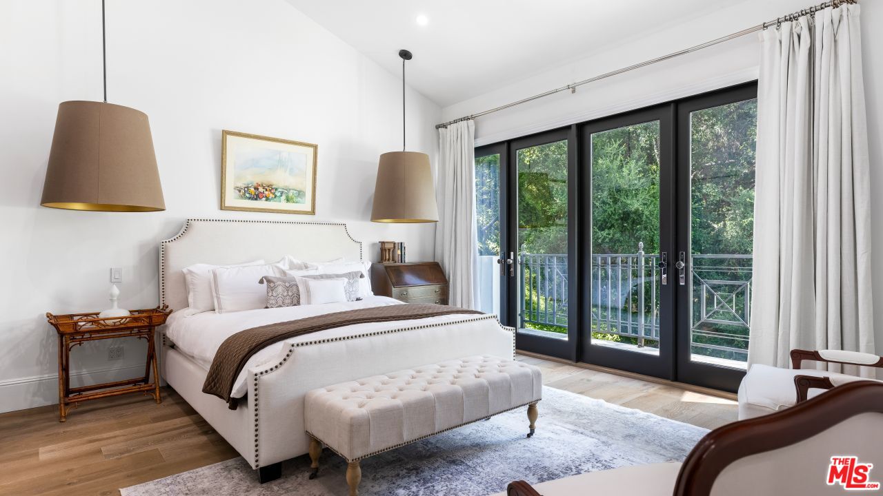 2231 Benedict Canyon Drive Beverly Hills, CA 90210 - Photo 34 of 50 a spacious bedroom with a bed a couch and a window