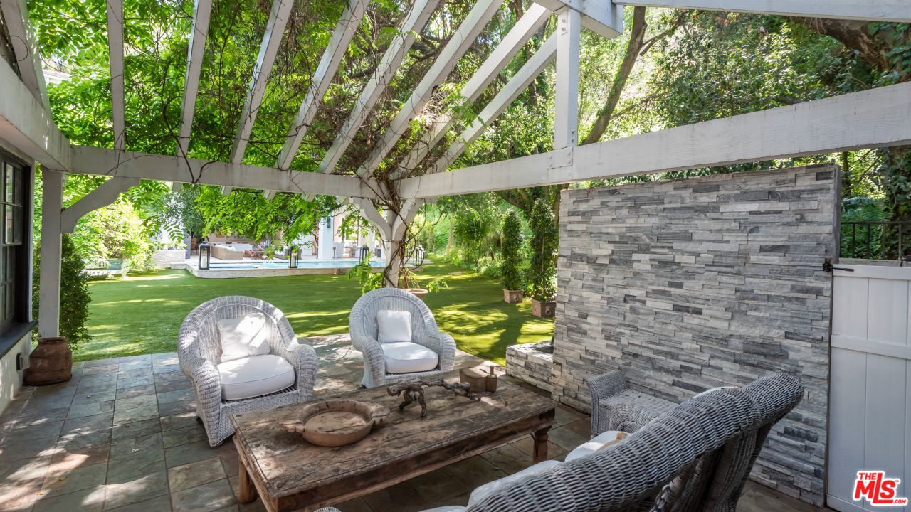 2231 Benedict Canyon Drive Beverly Hills, CA 90210 - Photo 43 of 50 a view of a porch with a table chairs and a yard