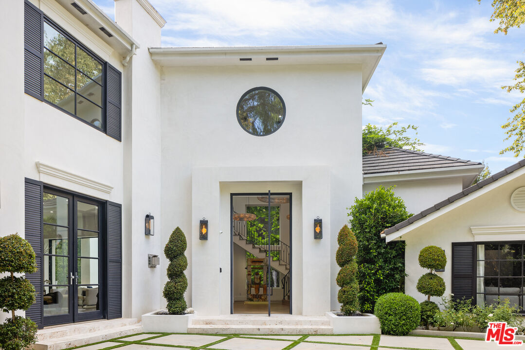 2231 Benedict Canyon Drive Beverly Hills, CA 90210 - Photo 8 of 50 a front view of a house with garden