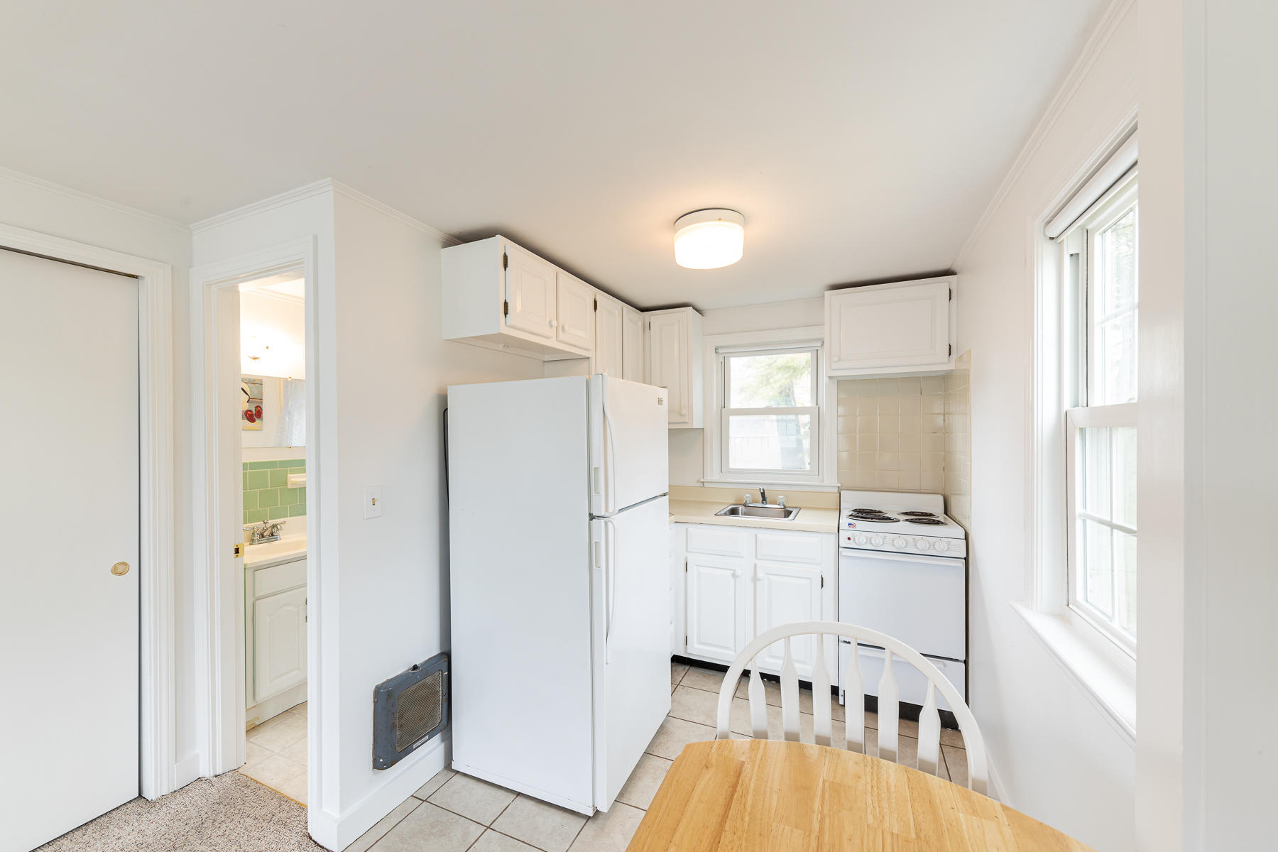 49 Lower County Road Dennis, MA 02639 - Photo 13 of 19 a kitchen with white cabinets and refrigerator