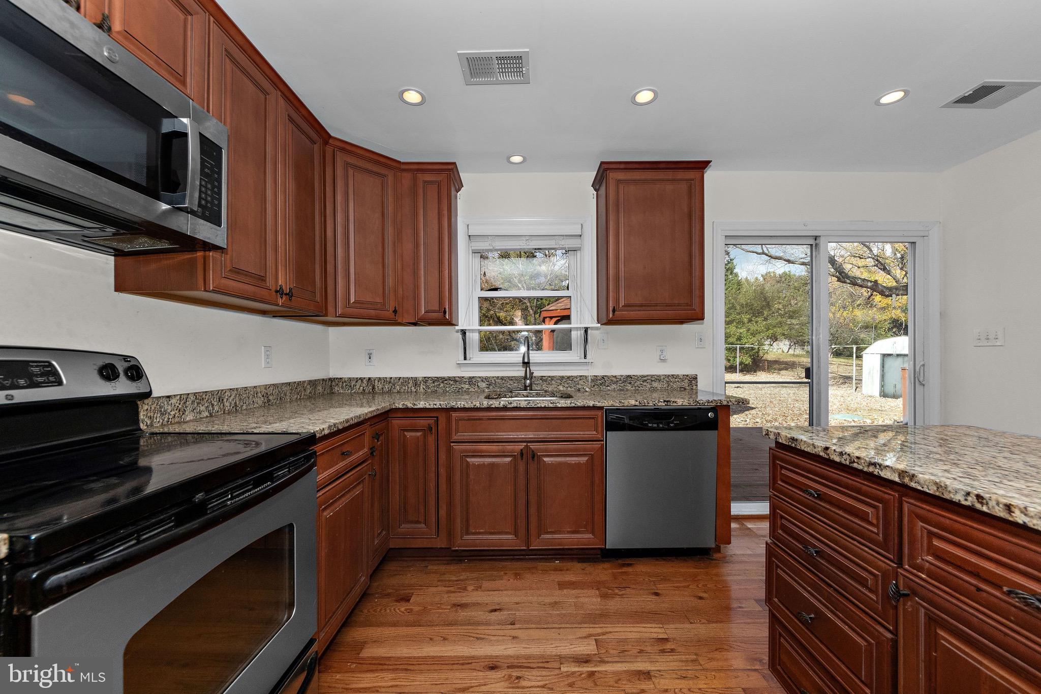 115 Valley View Avenue Edgewater, MD 21037 - Photo 12 of 56 a kitchen with stainless steel appliances granite countertop wooden cabinets stove top oven and sink