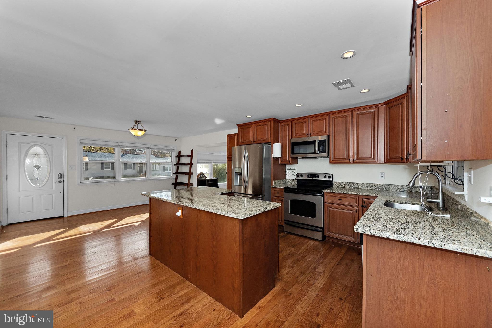 115 Valley View Avenue Edgewater, MD 21037 - Photo 10 of 56 a large kitchen with stainless steel appliances granite countertop a stove top oven a sink dishwasher and wooden cabinets with wooden floor