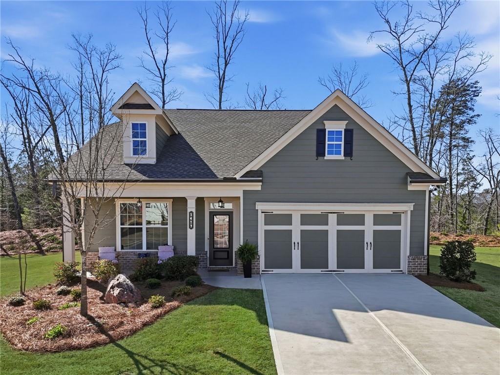 1413 Bluffs Ridge Way Canton, GA 30114 - Photo 1 of 62 a view of a yard in front of a brick house with large windows