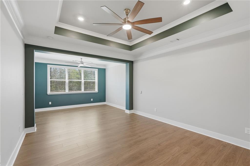 1413 Bluffs Ridge Way Canton, GA 30114 - Photo 17 of 62 an empty room with wooden floor chandelier fan and windows