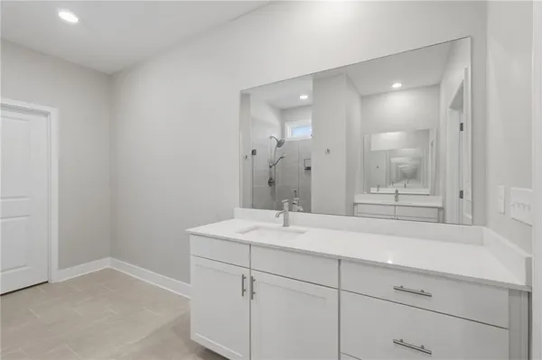 a bathroom with a shower sink vanity and mirror