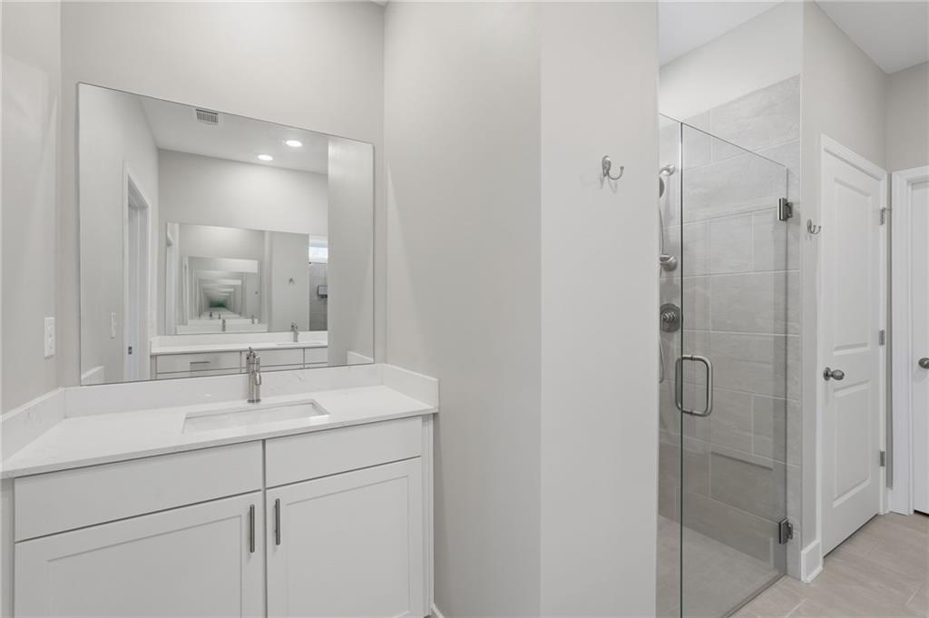 1413 Bluffs Ridge Way Canton, GA 30114 - Photo 24 of 62 a bathroom with a shower sink vanity and mirror