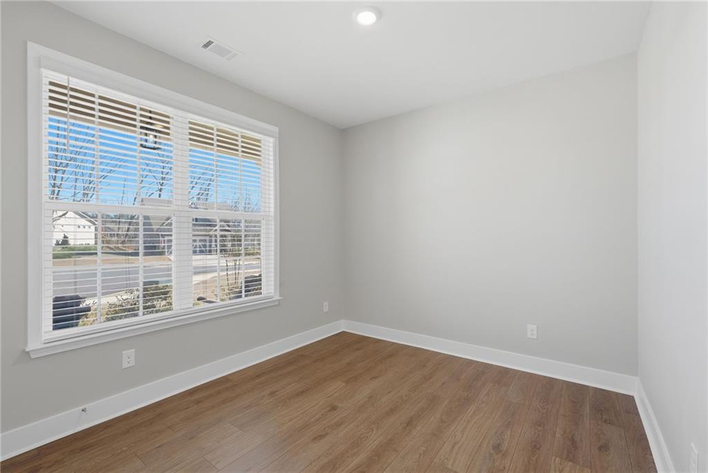 1413 Bluffs Ridge Way Canton, GA 30114 - Photo 27 of 62 an empty room with wooden floor and windows