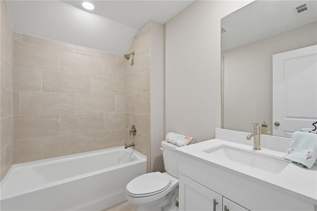 1413 Bluffs Ridge Way Canton, GA 30114 - Photo 33 of 62 a bathroom with a toilet a sink and bathtub