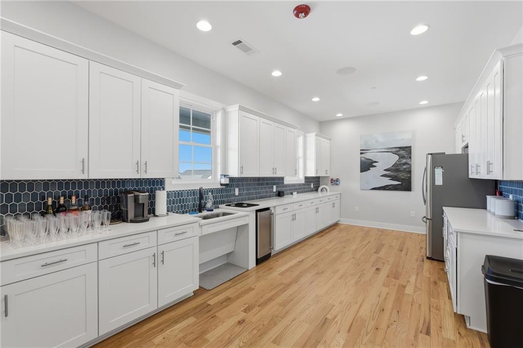 1413 Bluffs Ridge Way Canton, GA 30114 - Photo 50 of 62 a kitchen with white cabinets and appliances