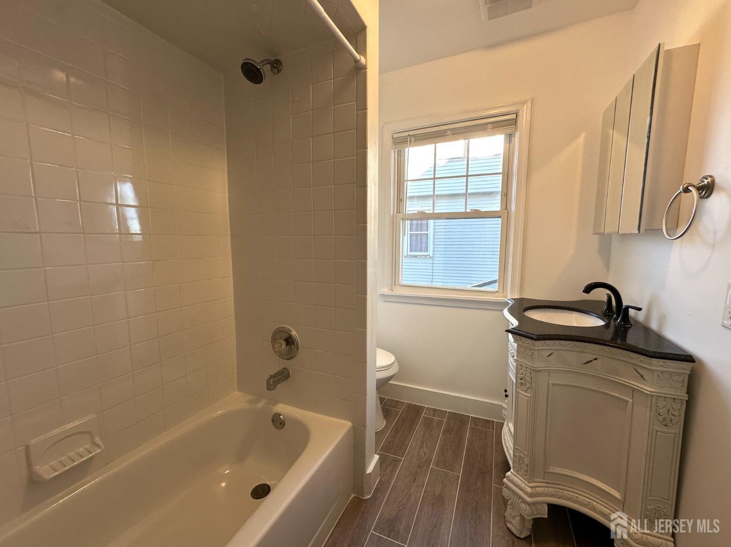 511 Grove Street Dunellen, NJ 08812 - Photo 9 of 9 a bathroom with a tub sink and mirror