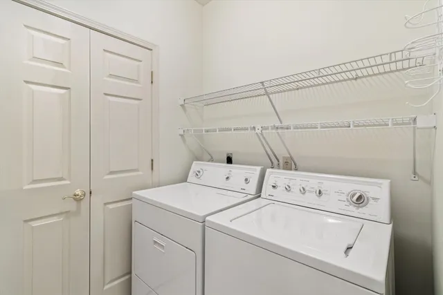 a spacious bedroom with a balcony a bed and a chandelier