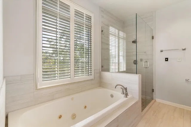 a bathroom with a tub a window and a shower
