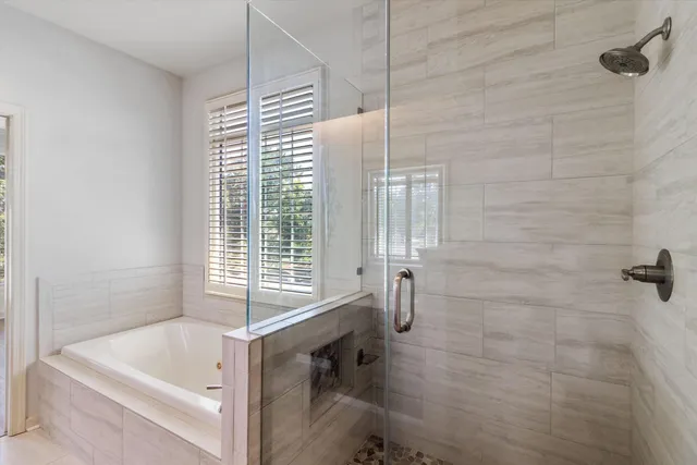 a bedroom with a bed a couch and potted plant