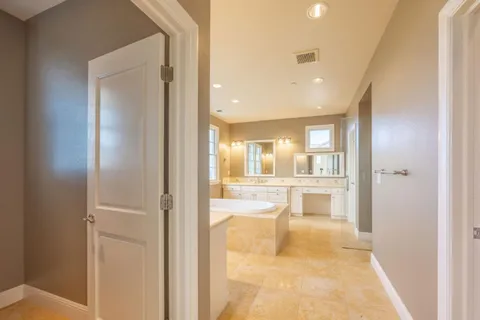 a spacious bathroom with a tub sink and mirror