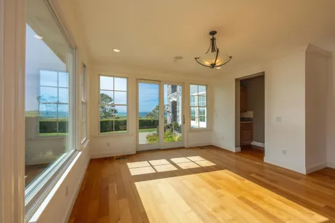 a view of a room with wooden floor and windows