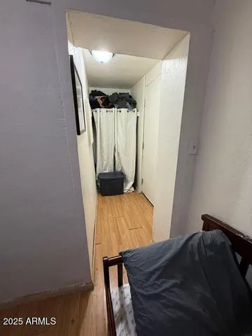 a view of a bedroom with wooden floor and furniture