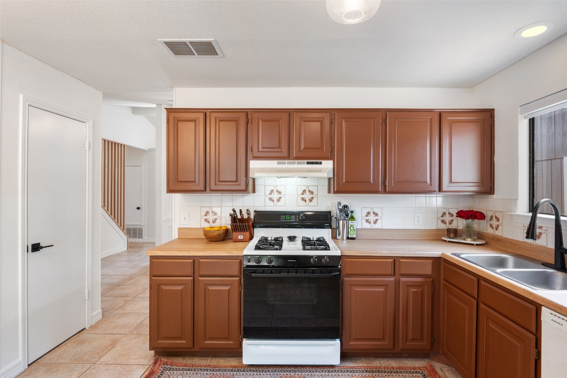9833 Briar Ridge Drive Austin, TX 78748 - Photo 8 of 29 a kitchen with stainless steel appliances a stove a sink a refrigerator and cabinets