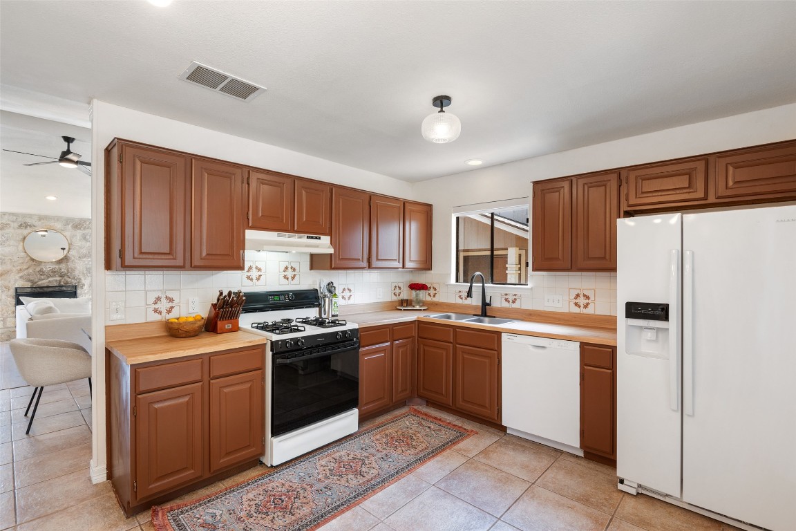 9833 Briar Ridge Drive Austin, TX 78748 - Photo 9 of 29 a kitchen with a sink stove and refrigerator