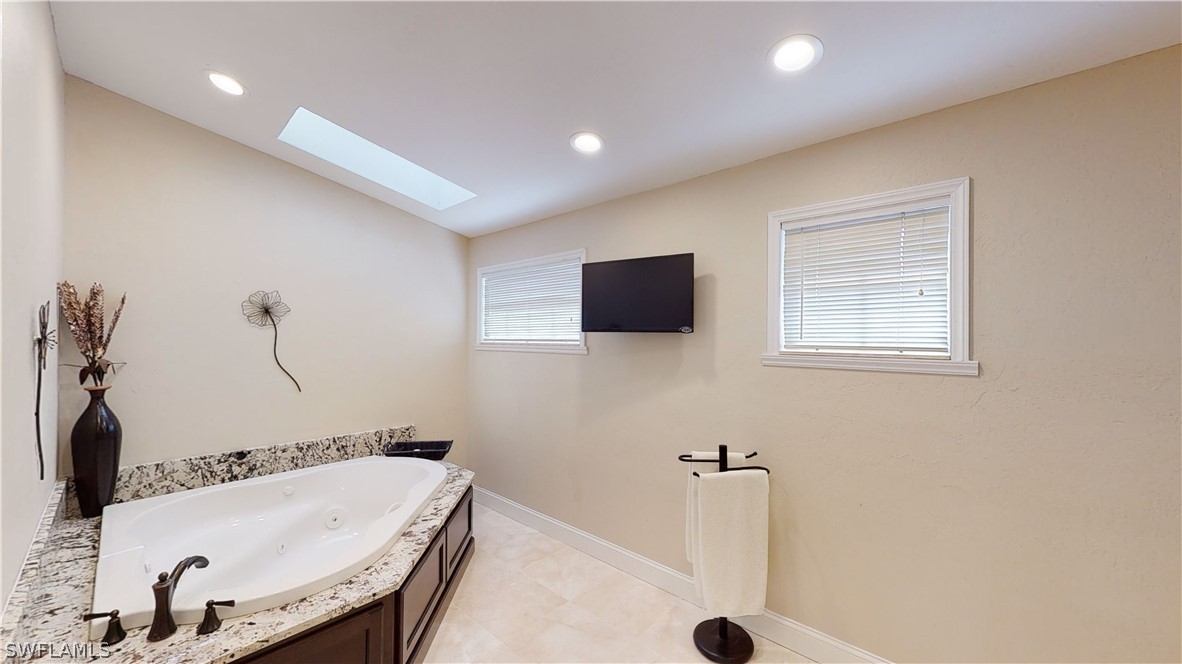14565 Eagle Ridge Drive Fort Myers, FL 33912 - Photo 23 of 28 a bathroom with a tub sink and mirror