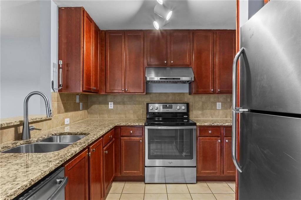 3650 Ashford Dunwoody Road Northeast, Unit 227 Atlanta, GA 30319 - Photo 11 of 23 a kitchen with a sink a refrigerator and cabinets