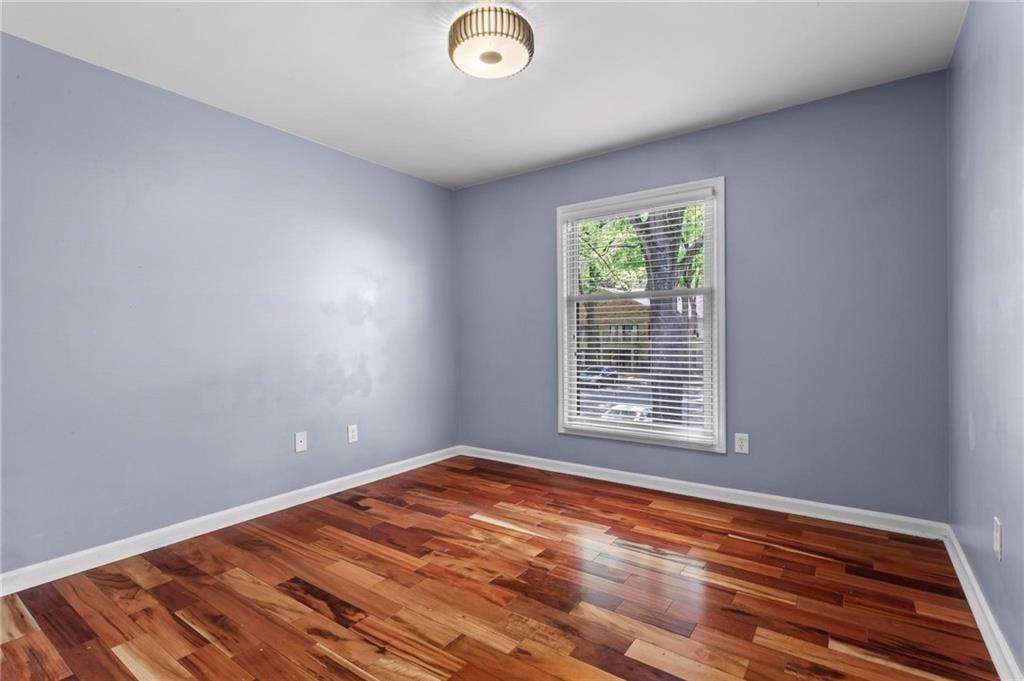 3650 Ashford Dunwoody Road Northeast, Unit 227 Atlanta, GA 30319 - Photo 14 of 23 a view of an empty room with wooden floor and a window