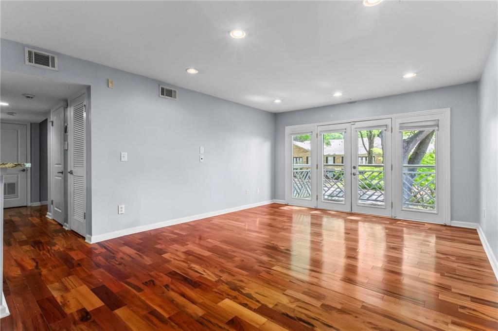 3650 Ashford Dunwoody Road Northeast, Unit 227 Atlanta, GA 30319 - Photo 7 of 23 a view of an empty room with wooden floor and a window