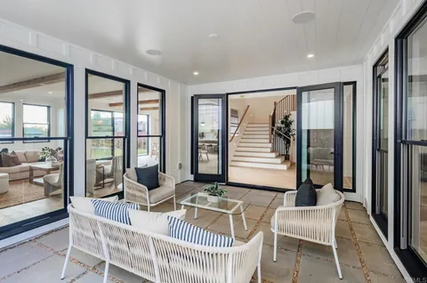 a living room with furniture and large windows