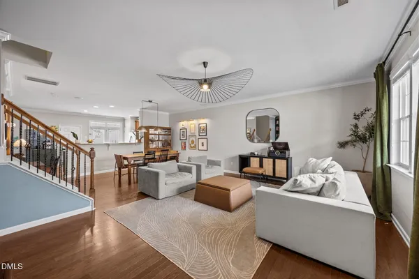 a living room with furniture kitchen view and a wooden floor