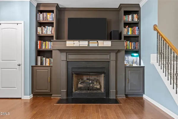 a living room with a fireplace and a book shelf