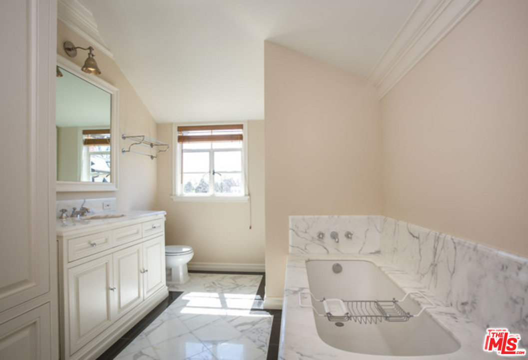 171 South Rodeo Drive Beverly Hills, CA 90212 - Photo 12 of 21 a spacious bathroom with a toilet sink and mirror