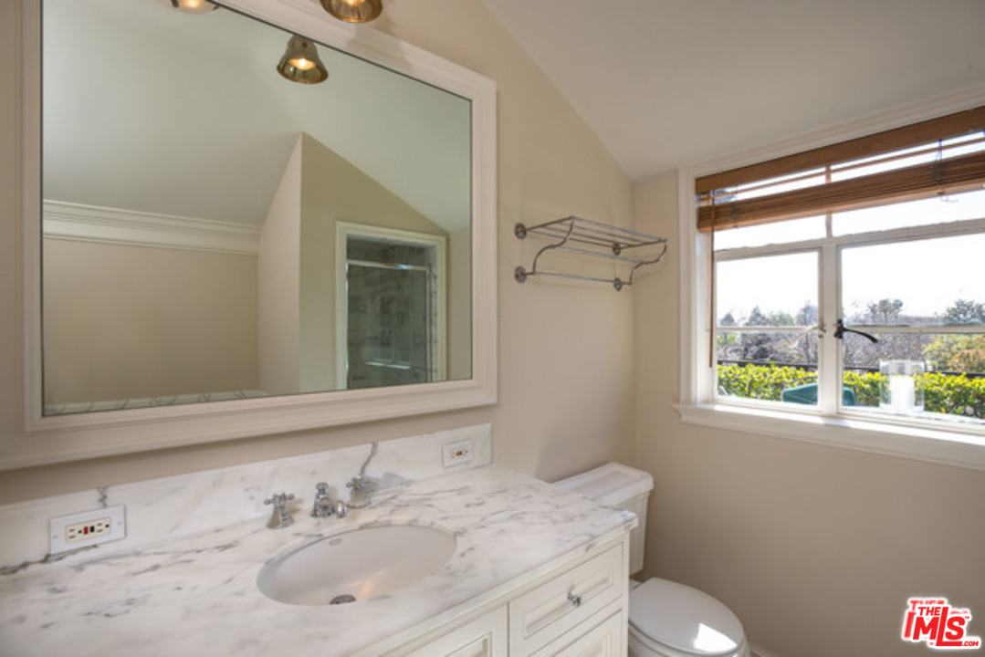 171 South Rodeo Drive Beverly Hills, CA 90212 - Photo 13 of 21 a bathroom with a sink toilet a mirror and next to a window