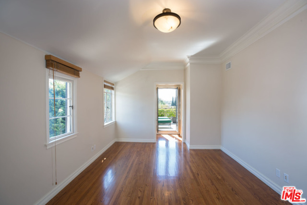 171 South Rodeo Drive Beverly Hills, CA 90212 - Photo 17 of 21 a view of an empty room with wooden floor and a window