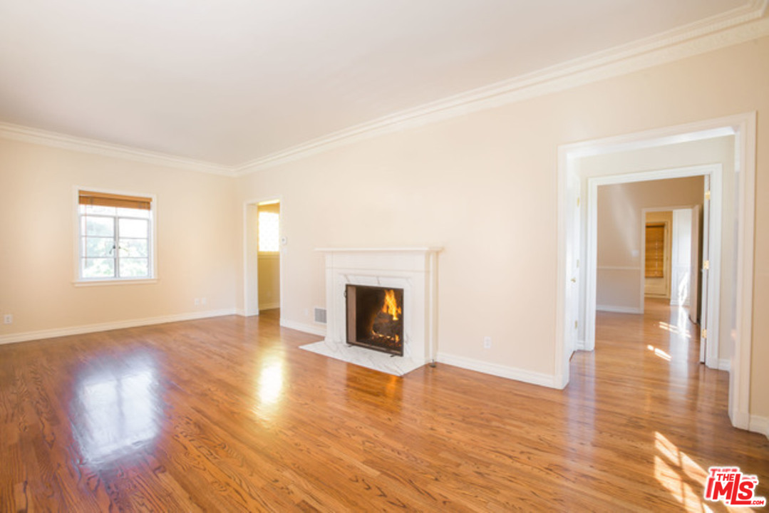 171 South Rodeo Drive Beverly Hills, CA 90212 - Photo 3 of 21 an empty room with wooden floor fireplace and windows