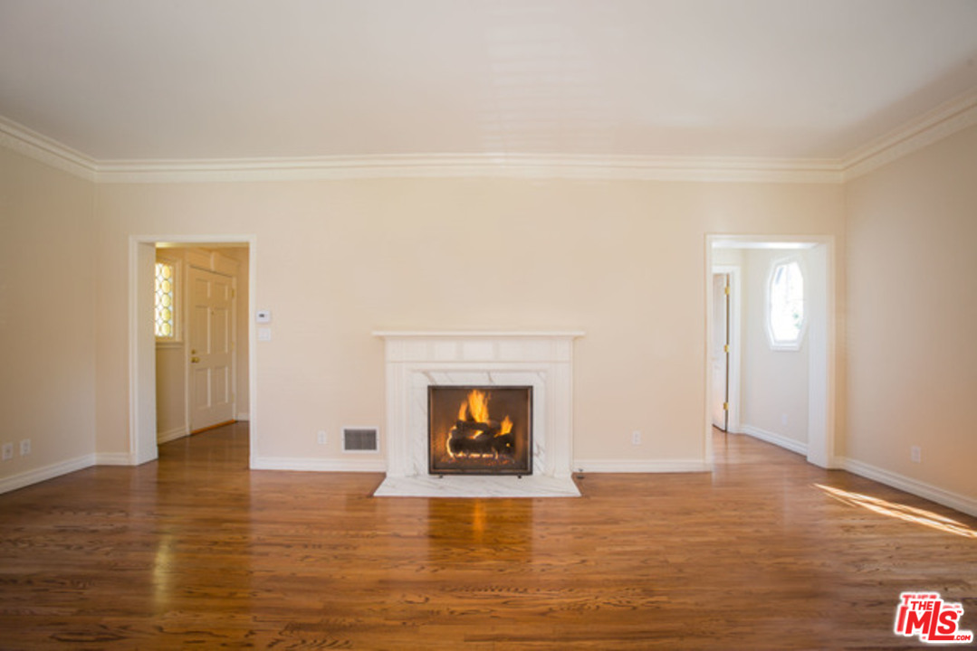 171 South Rodeo Drive Beverly Hills, CA 90212 - Photo 4 of 21 a view of an empty room with wooden floor and a fireplace