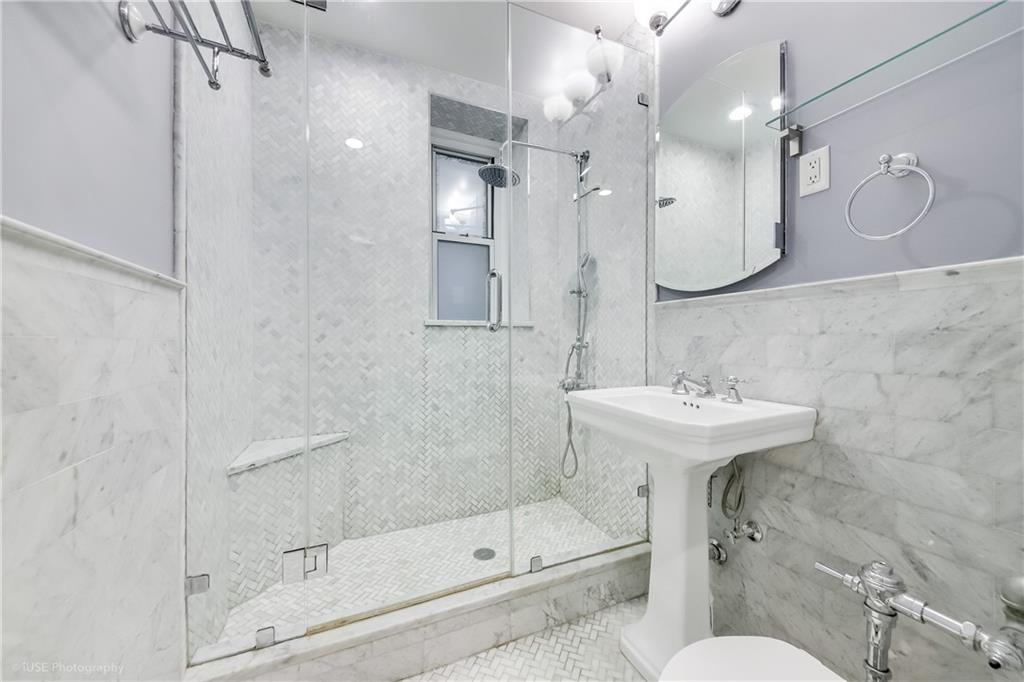 8701 Shore Road, Unit 137 Brooklyn, NY 11209 - Photo 5 of 11 a bathroom with a sink a toilet and shower