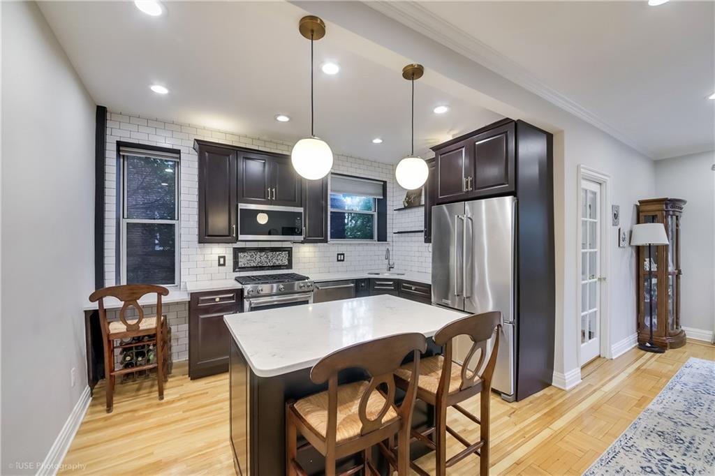 8701 Shore Road, Unit 137 Brooklyn, NY 11209 - Photo 6 of 11 a kitchen with a table chairs refrigerator and microwave