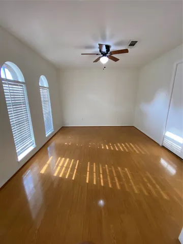 an empty room with windows and fan