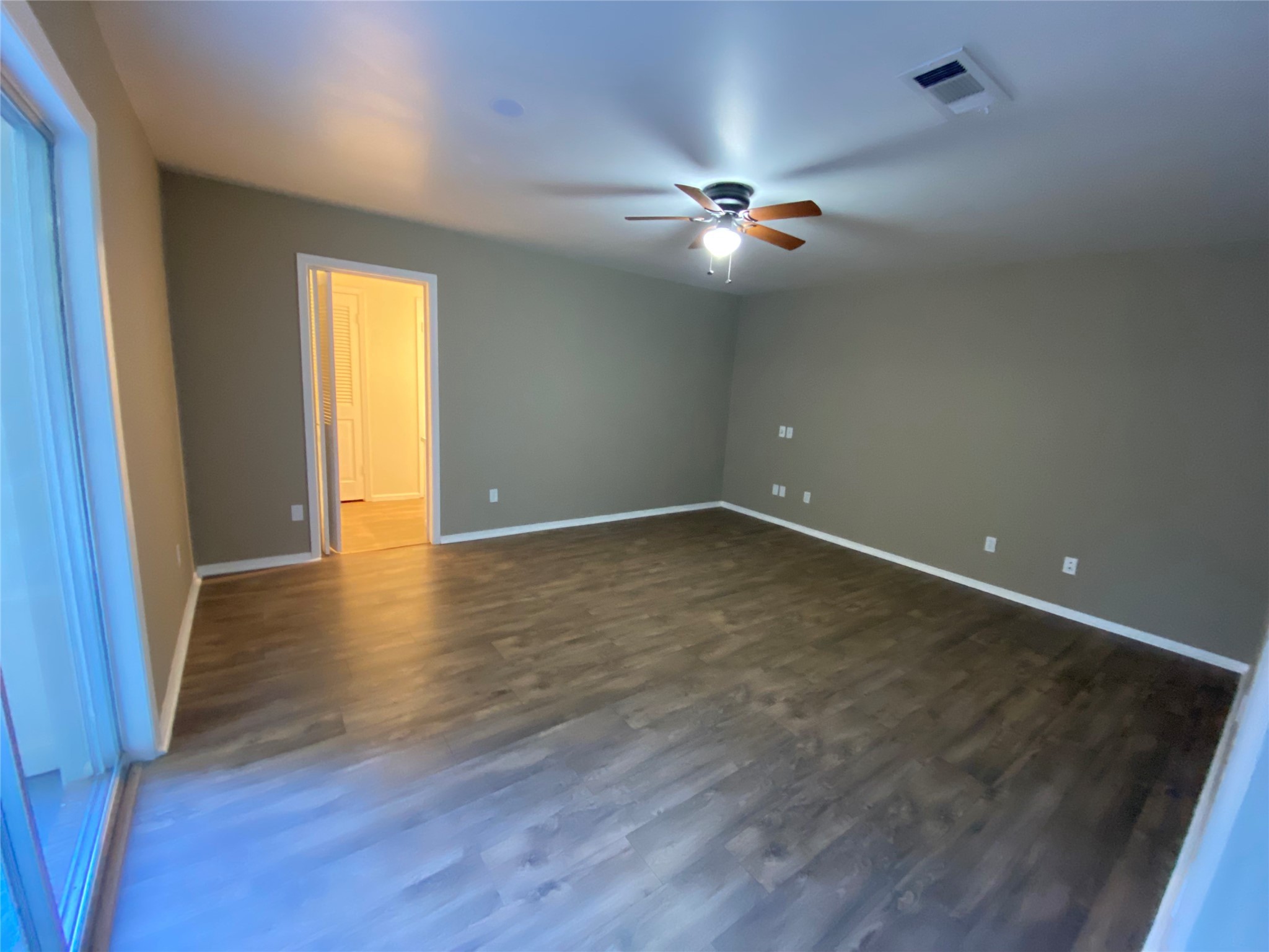 1408 Ward Bend Road Sealy, TX 77474 - Photo 25 of 36 a view of an empty room with wooden floor and fan
