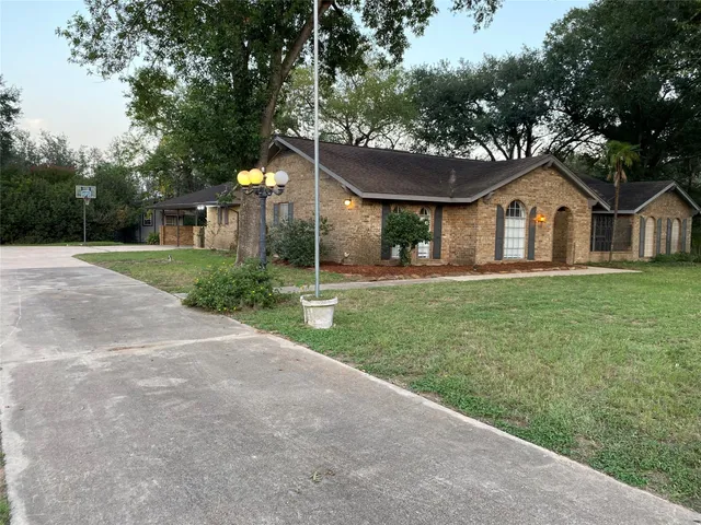 a front view of a house with a yard and trees