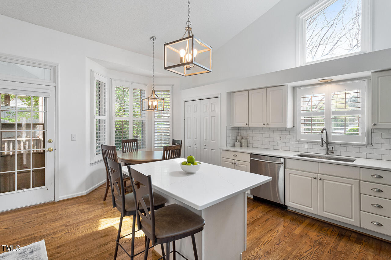 2320 Kendricks Court Raleigh, NC 27613 - Photo 8 of 35 a kitchen that has a table chairs in it wooden floors and white walls