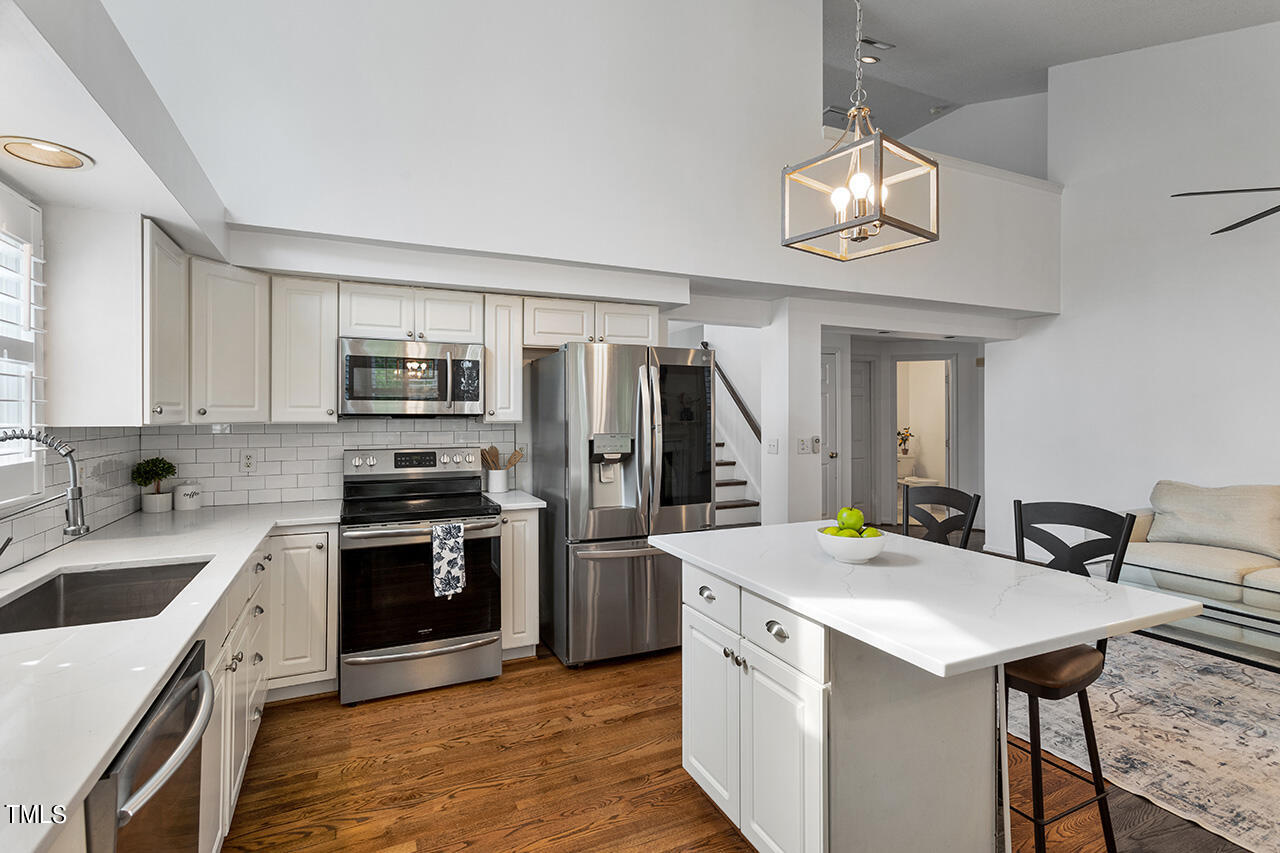 2320 Kendricks Court Raleigh, NC 27613 - Photo 9 of 35 a kitchen that has a kitchen island wooden cabinets and stainless steel appliances