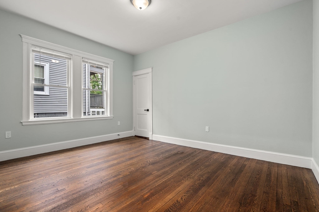 21-23 Westmore Road Boston, MA 02126 - Photo 15 of 42 a view of an empty room with wooden floor and a window