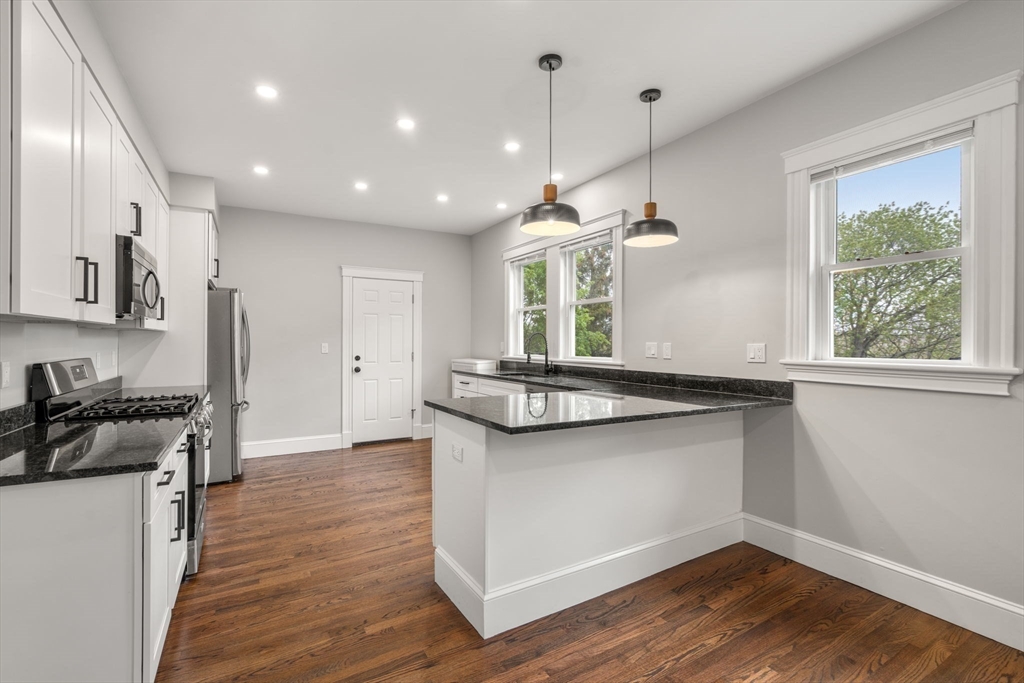 21-23 Westmore Road Boston, MA 02126 - Photo 29 of 42 a kitchen with stainless steel appliances granite countertop a stove a sink a refrigerator and a window