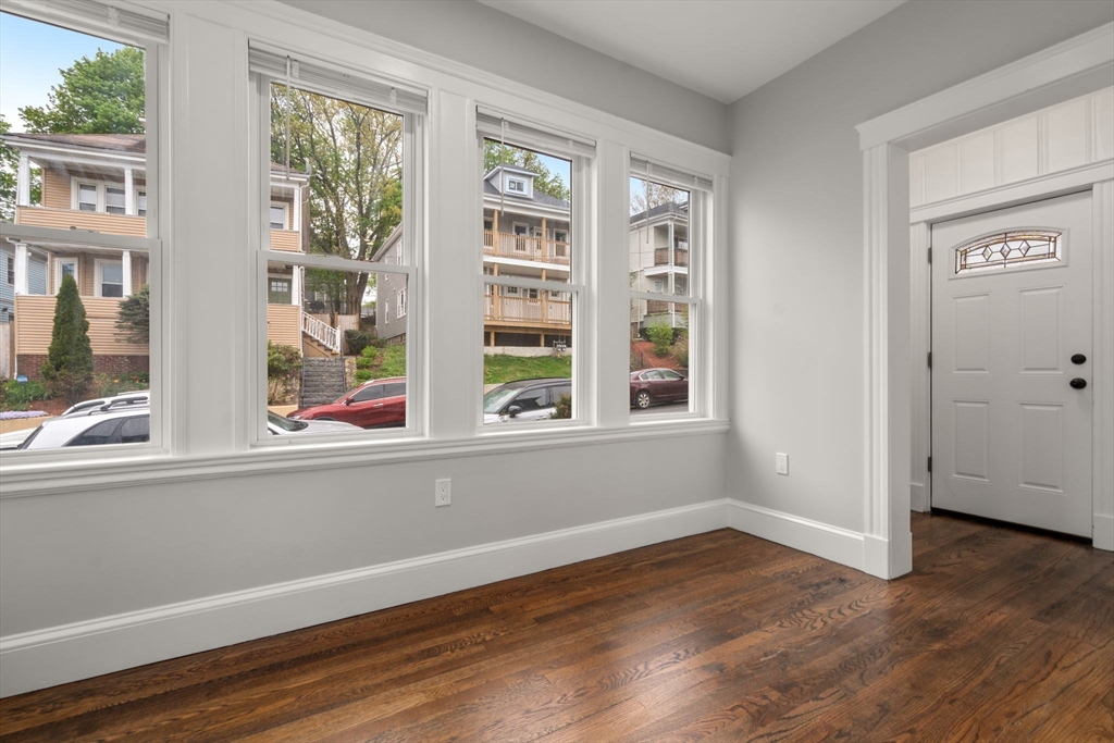 21-23 Westmore Road Boston, MA 02126 - Photo 3 of 42 an empty room with wooden floor and windows