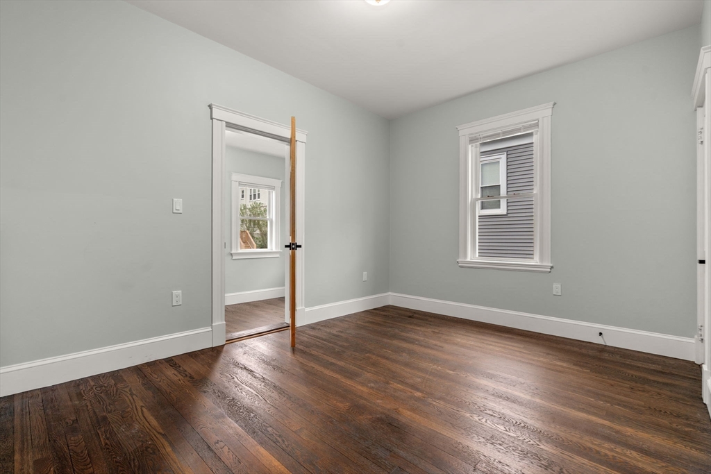 21-23 Westmore Road Boston, MA 02126 - Photo 31 of 42 an empty room with wooden floor and windows